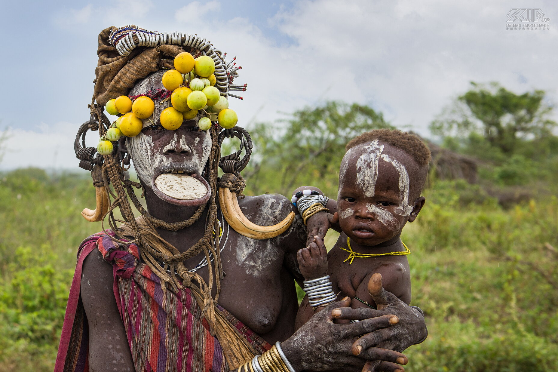 Mago - Mursi woman with child In Mago NP we drove to the region where the Mursi tribes live. The women often wear a clay dish in their lower lip and men decorate their bodies with figurative incisions and painted patterns. The Mursi still live very traditional and livestock, mainly cattle, is their most valued possession and also a measure of social status. The Mursi left a big impression on us and these people still have a long way to go to enter modern times. Stefan Cruysberghs